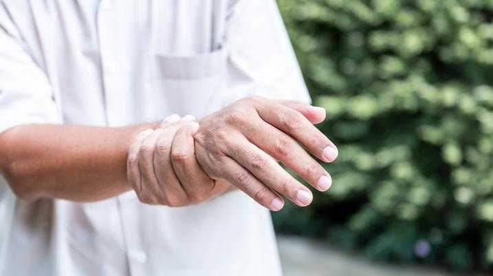 Elderly person holding their wrist in pain