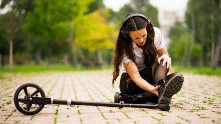 Woman on ground suffering a Scooter Ankle Injury