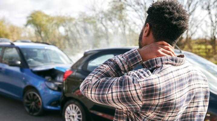 Man rubbing neck in pain after car accident