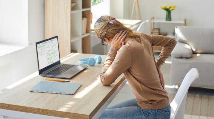 Woman experiencing neck and back arthritis pain at workstation