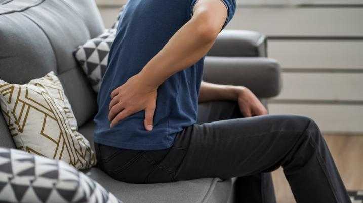 Man sitting on couch with back pain