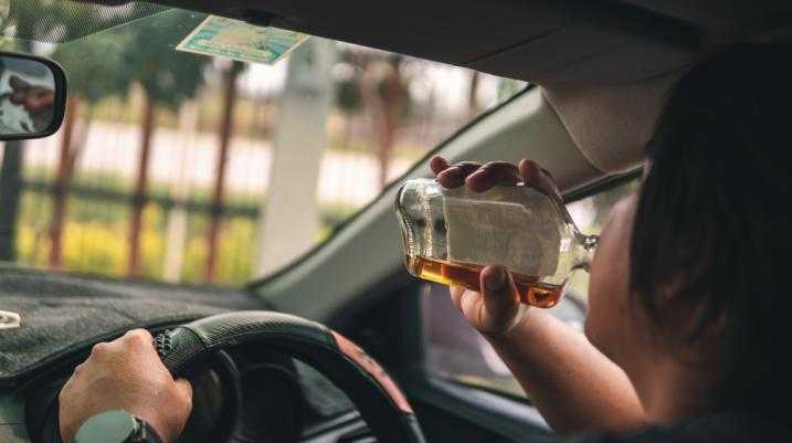 Man drinking alcohol while driving