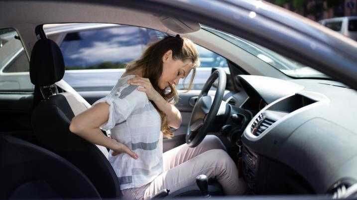 Woman experiencing back pain after a car accident