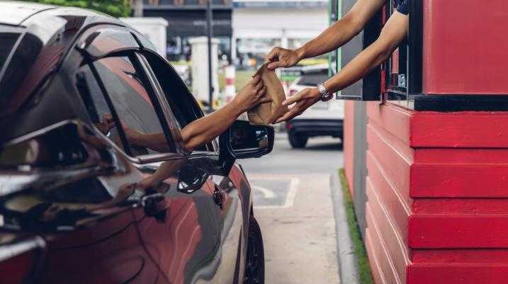 Someone being handed food in a drive-thru