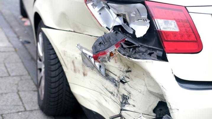 White car with a severely damaged tail light