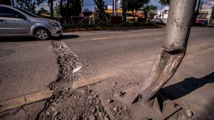 Car driving over a large pothole on the street