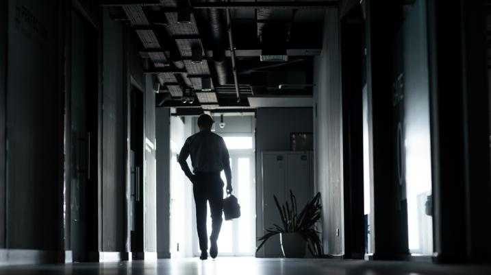 Businessman walking through a dark hallway