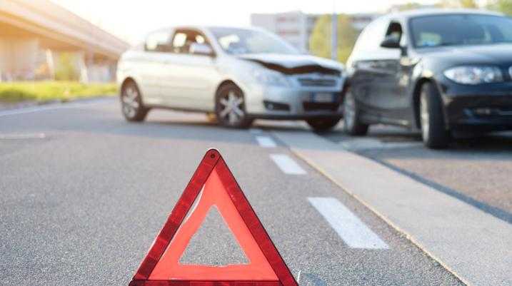 Cone on the road in front of a car accident