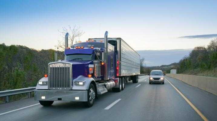 Semi truck driving next to a car