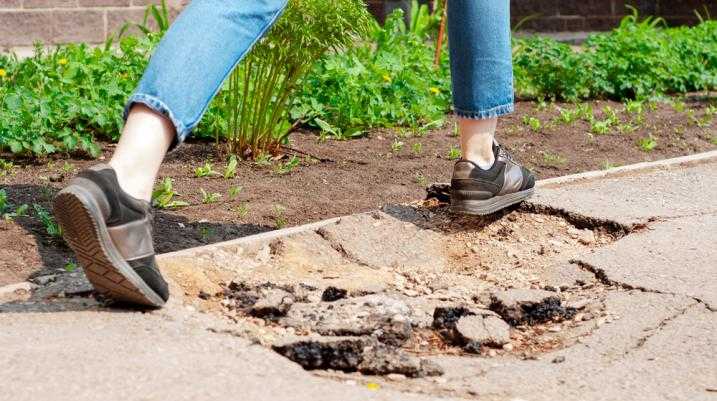 Woman walking over pothole