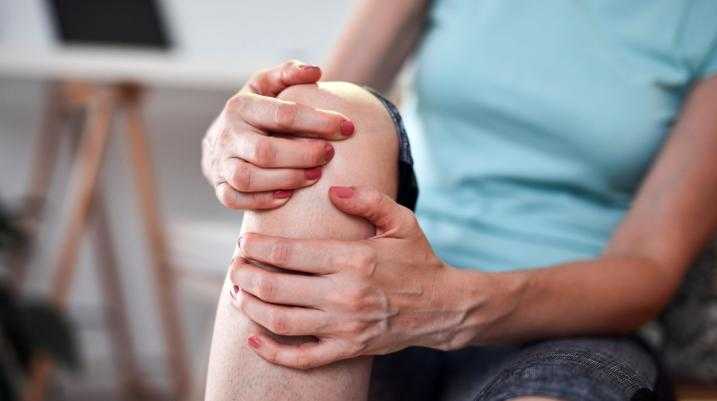 Woman holding her knee is pain