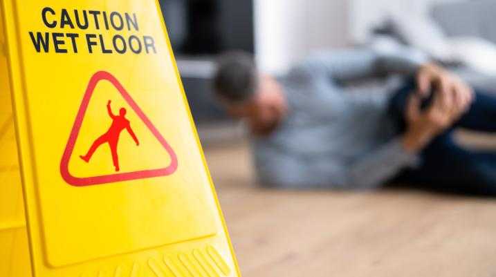 man on the floor with the caution wet floors sign