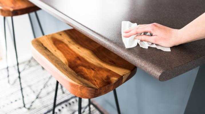 Person cleaning the table with a wipe