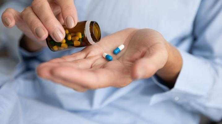 Woman pouring two pills into her hand