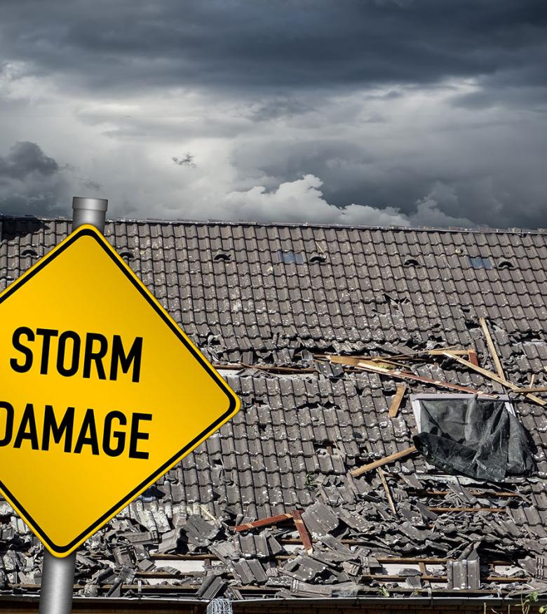 Wrecked Roof with Storm Damage Sign