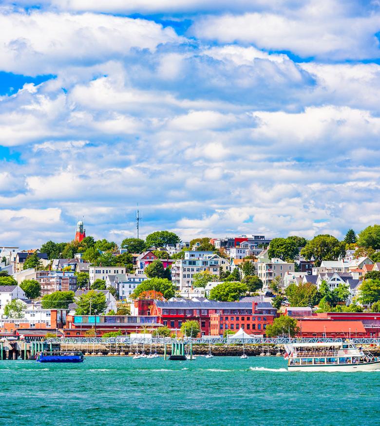 Scenic view of Portland, Maine coastline with colorful buildings and bustling harbor on a sunny day