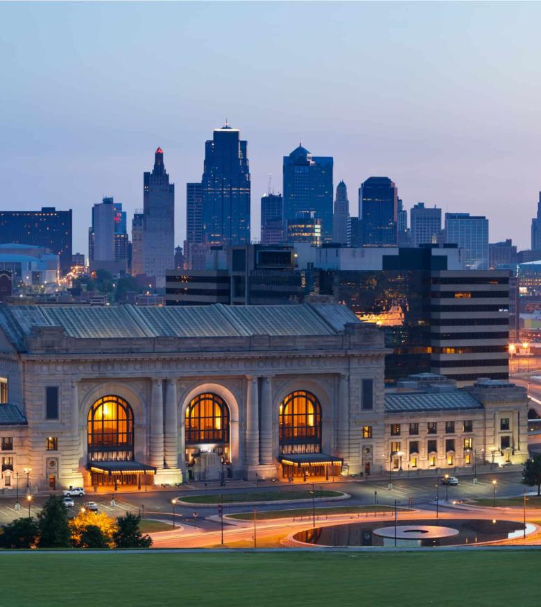 Twilight view of Kansas City skyline behind lit classical architecture, a strategic spot for personal injury lawyers.