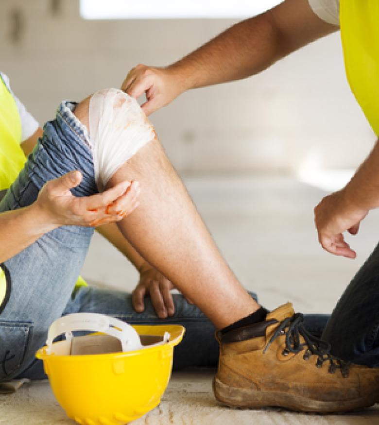 Construction worker receiving first aid for an injury, contact a lawyer in Melbourne.