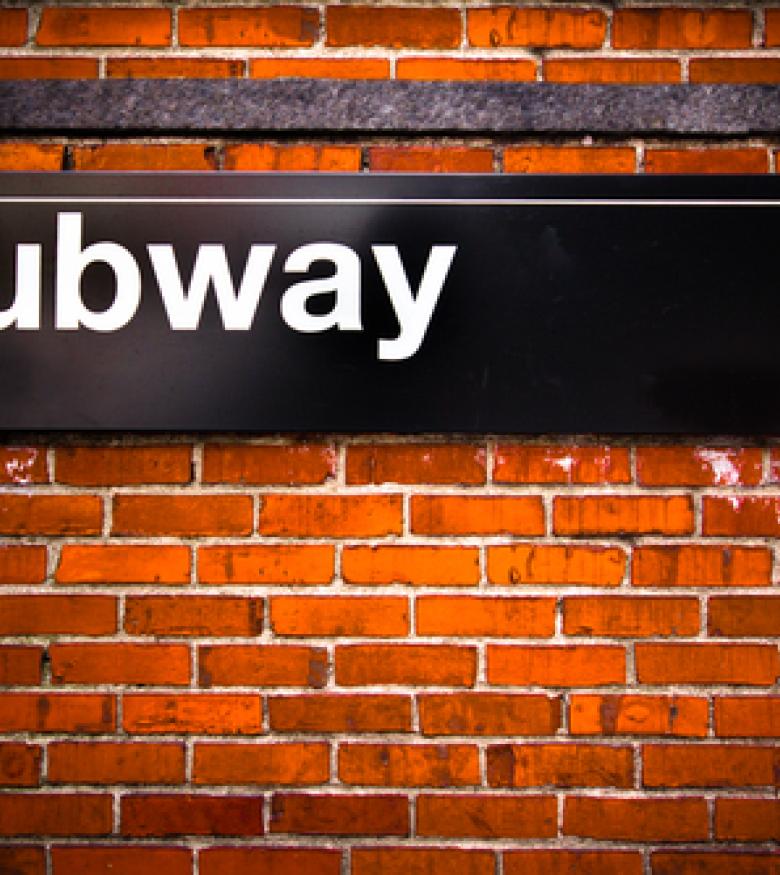 A subway sign on a brick wall, highlighting the need for a Subway Accident Lawyer in The Bronx to provide legal assistance for subway-related incidents.