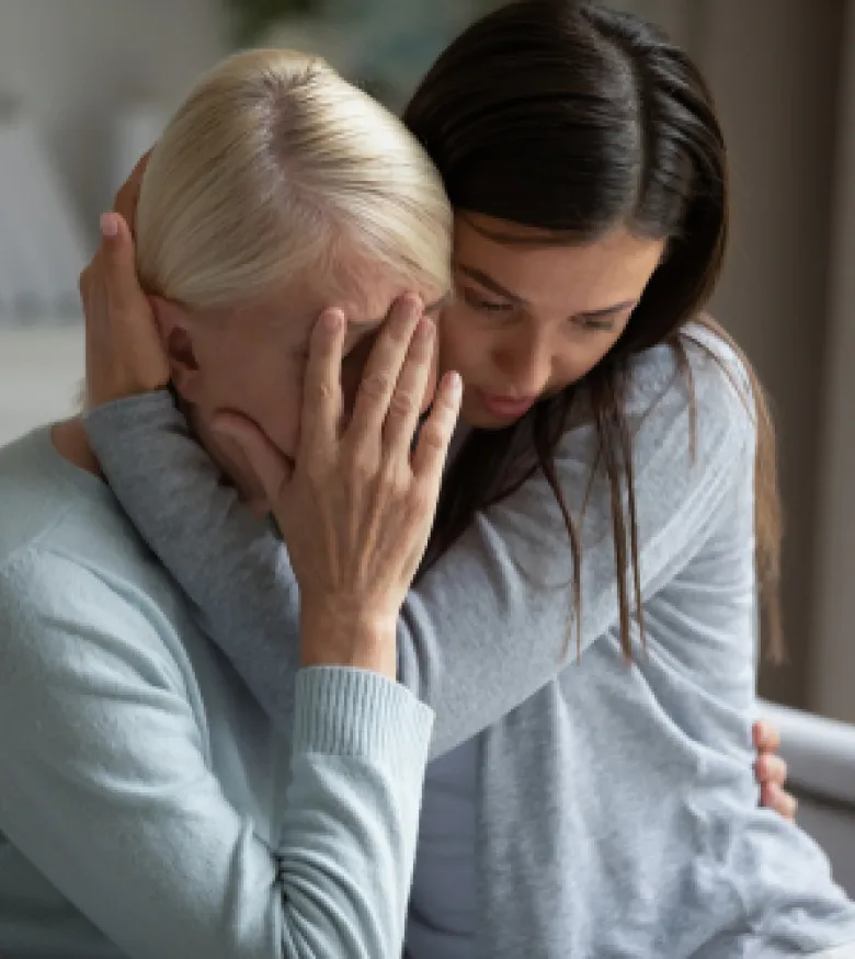 Two women embracing, appearing sorrowful and comforting each other, depicting the need for a Wrongful Death Attorney in The Bronx.