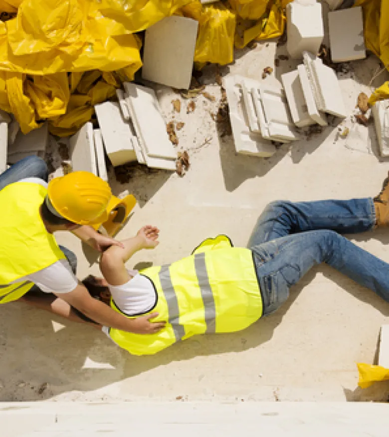 A construction worker receives assistance after an accident on site, highlighting the need for a Construction Accident Lawyer in Queens.