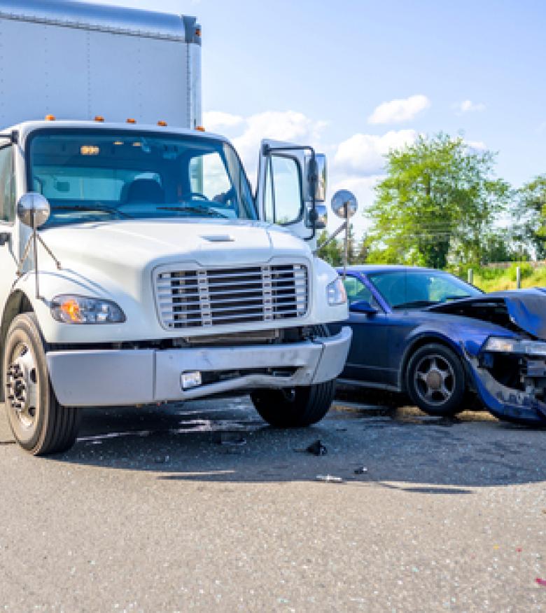 A damaged car and a truck involved in a collision, illustrating the need for a Truck Accident Attorney in Queens.