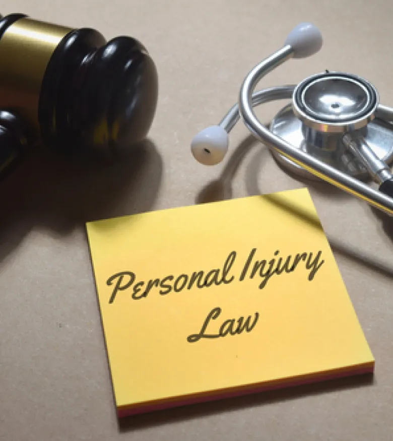 A gavel, stethoscope, and a note reading 'Personal Injury Law,' emphasizing the need for an Injury Attorney in Gainesville for legal assistance.