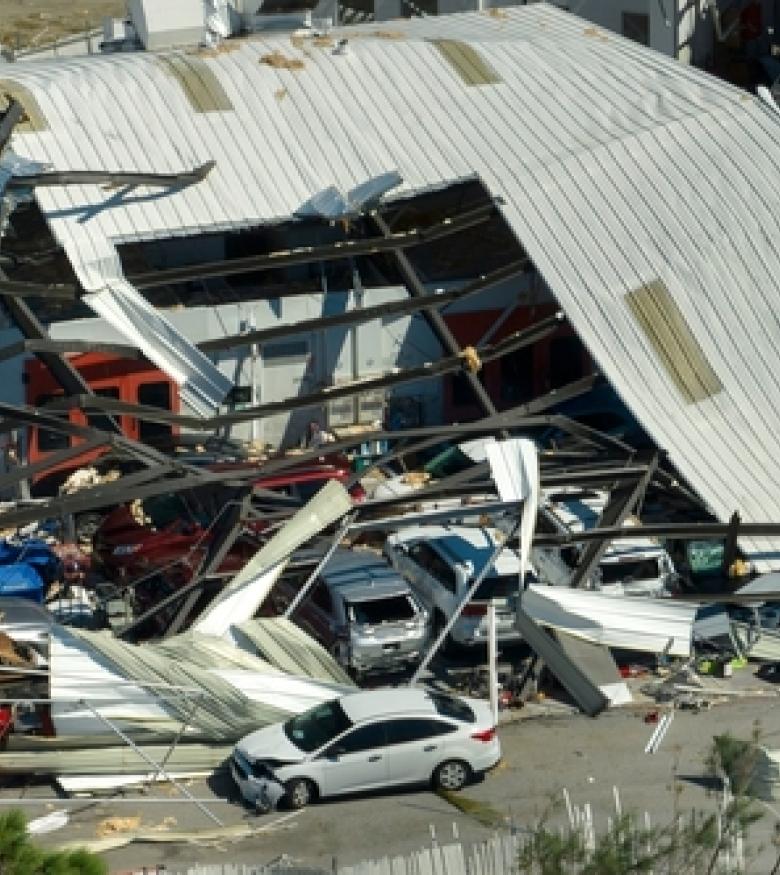 A collapsed building with debris and damaged vehicles, highlighting the devastating effects of a Building Collapse in Gainesville.