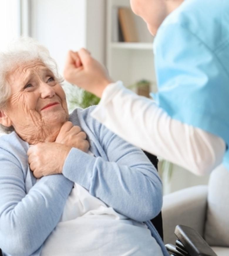 A nurse interacting with an elderly woman who looks distressed, highlighting the need for a Nursing Home Abuse Lawyer in Murfreesboro to provide legal assistance.