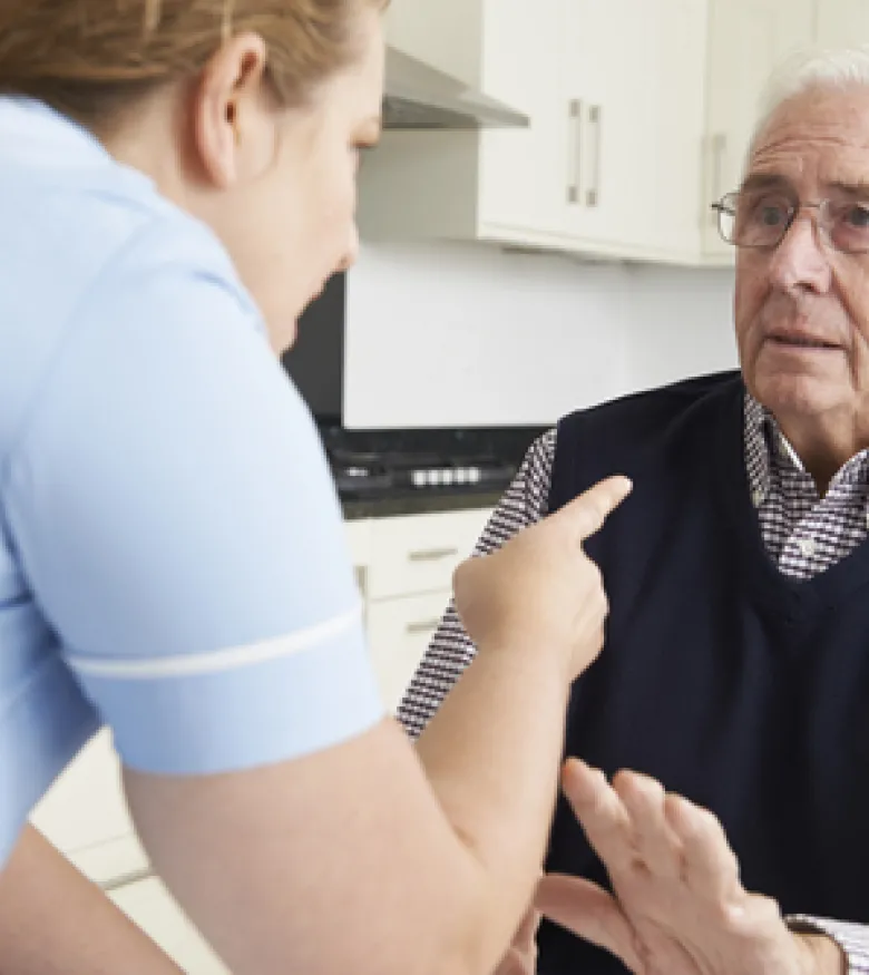 A caregiver pointing aggressively at an elderly man, highlighting the need for a Nursing Home Abuse Lawyer in Queens to provide legal assistance.