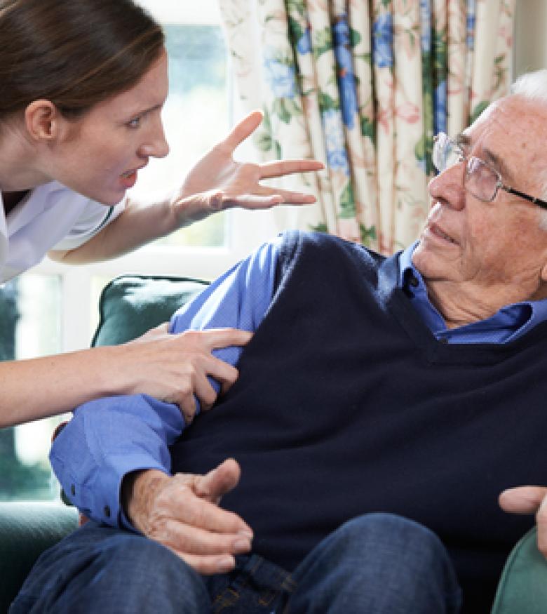 A caregiver aggressively confronting an elderly man, highlighting the need for a Nursing Home Abuse Lawyer in Brunswick to provide legal assistance.