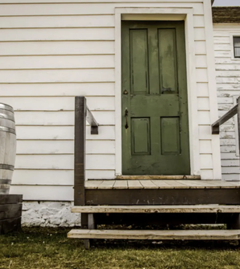 A deteriorating wooden deck in front of a house, highlighting the potential risk of a Deck Collapse in Bowling Green.