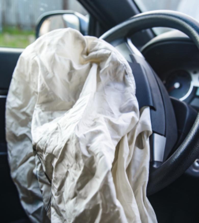 Interior view of a car with a deployed airbag, representing Airbag Injuries in Deland.