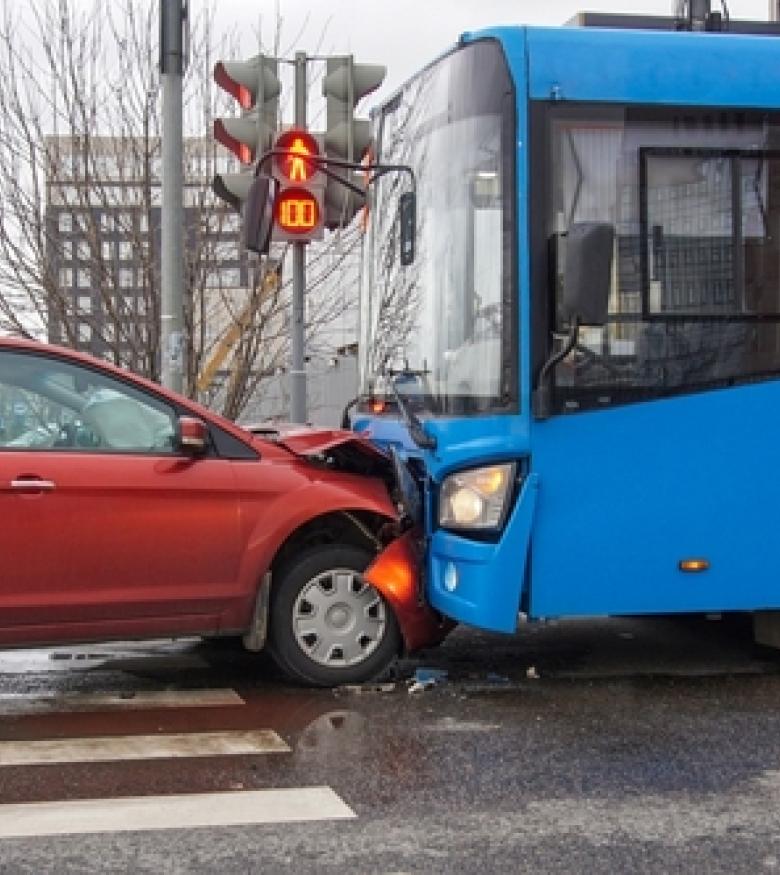 A red car collided with a blue bus at an intersection, highlighting the need for a Bus Accident Attorney in Gainesville to provide legal assistance.