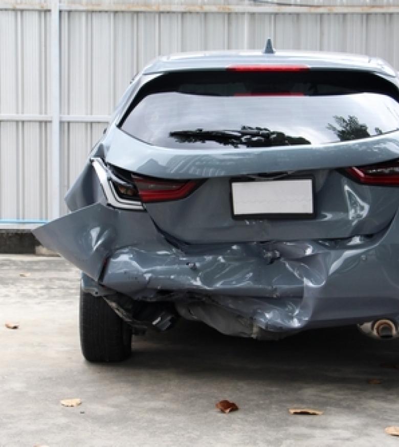 A grey car with significant rear-end damage in a parking lot, illustrating the need for a Car Wreck Lawyer in Orange Park.