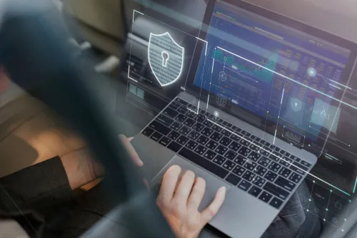 Cybersecurity concept with person using laptop showing digital security interface.
