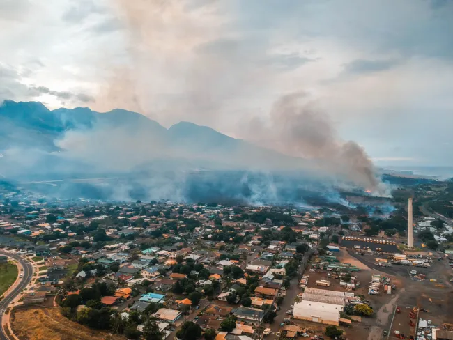 Arial view of smoke rising from a residential area in Maui due to wildfires