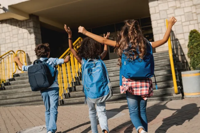 three kids outside of school