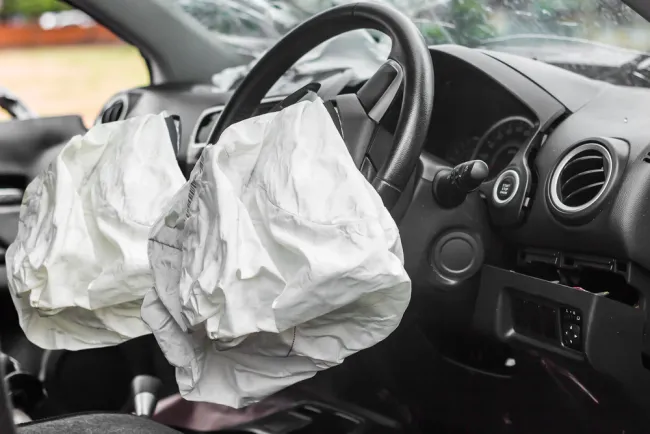 Deployed airbags in a car interior after a crash, illustrating the issue of defective airbags leading to Toyota's recall of over 145,000 vehicles.