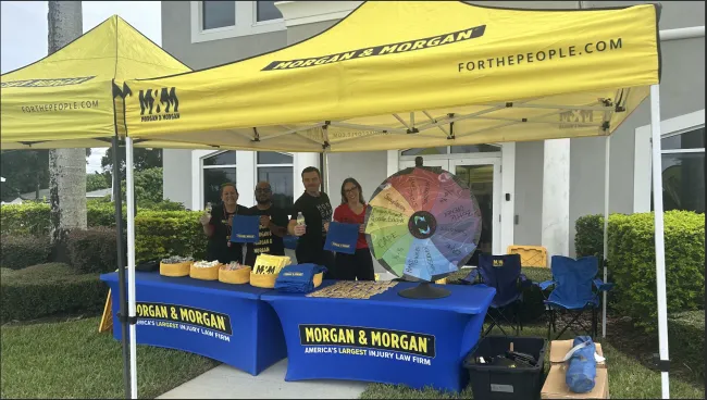 Team of Morgan and Morgan employees smiling by the tent