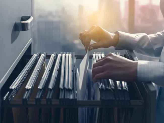 Person looking through files in a filing cabinet