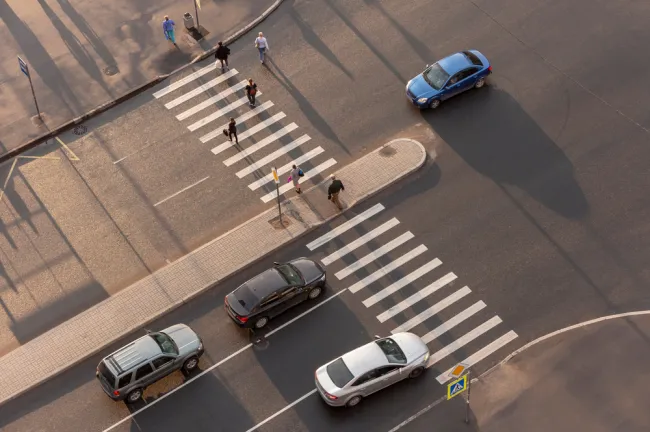 Pedestrians crossing the street with cars