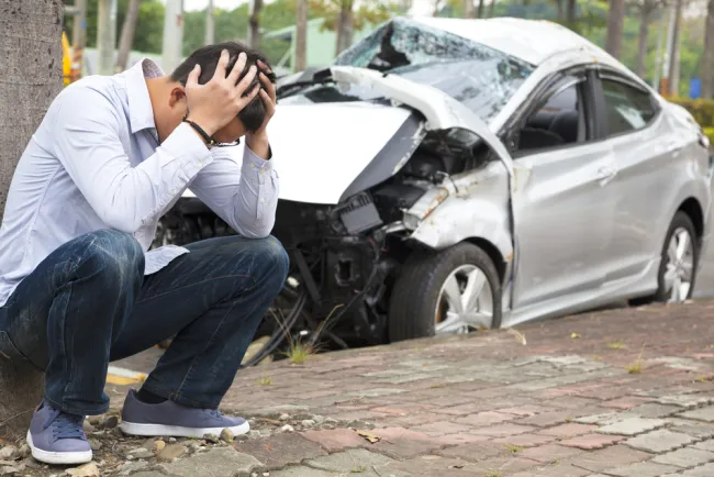 Man with his head in his hands after a car accident