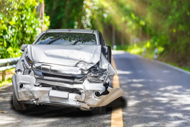 Grey car with damage on the road 