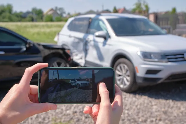 Someone taking a picture of a car crash