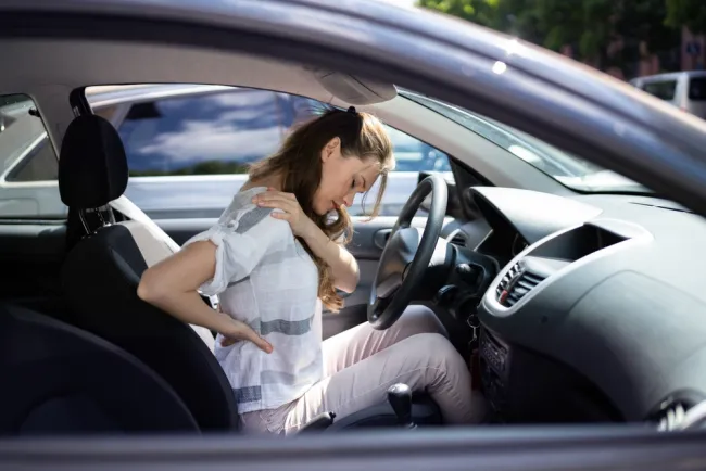 Woman experiencing back pain after a car accident