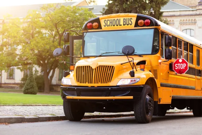 School bus parked next to sidewalk