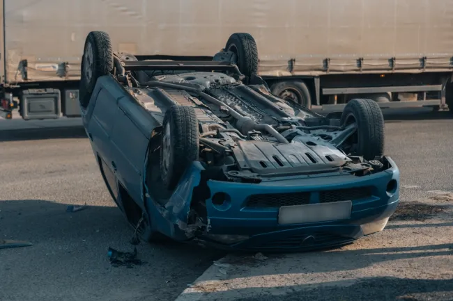 Car flipped upside down on the road