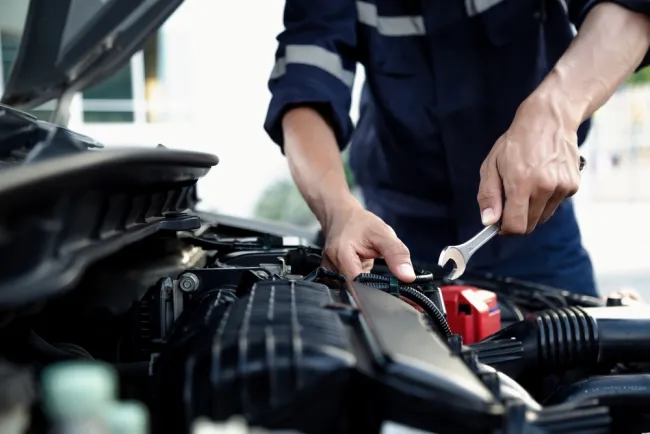 Mechanic fixing a part of a car