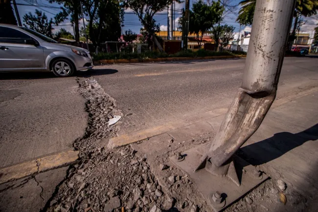 Car driving over a large pothole on the street